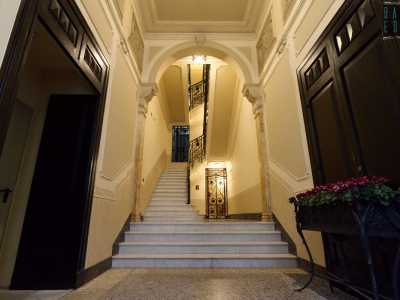 ...accediamo a un vano scala impreziosito da pannelli con scene classicheggianti e fregi liberty